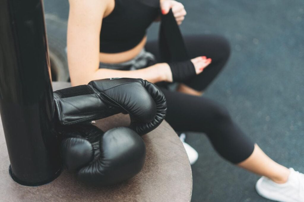 black leather boxing gloves background athletic girl shakes boxing bandages hands before training