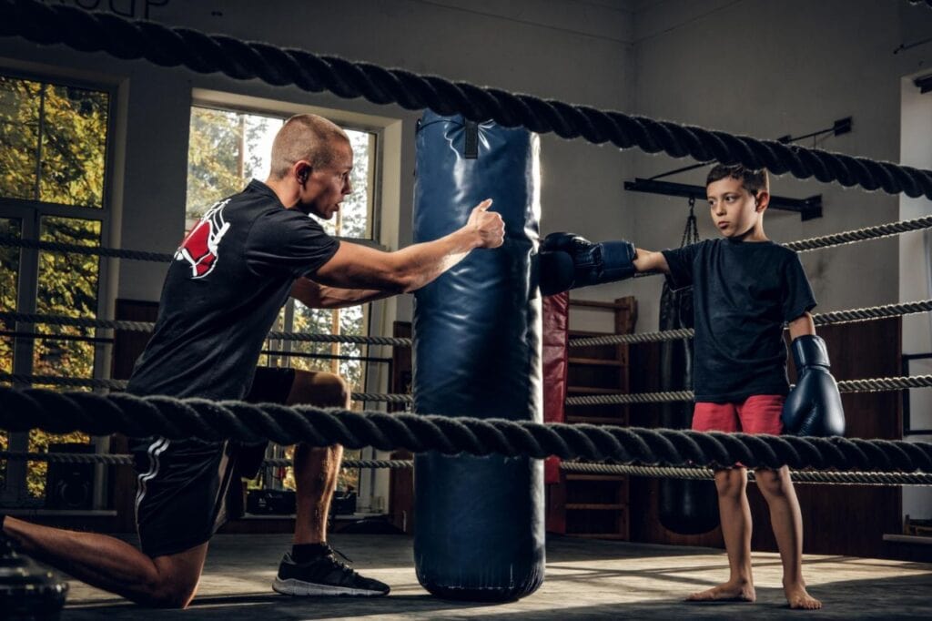 dark photo shoot kids training with big punching bag boxing studio