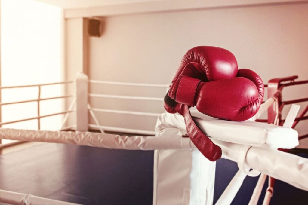 pair red boxing gloves hangs off ring