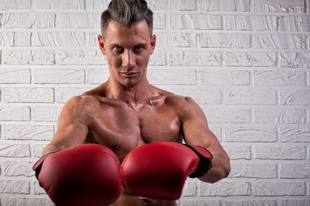 portrait handsome boxer man standing bric wall looking camera with intense gaze