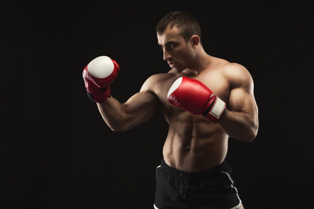 strong muscular man red boxing gloves black studio background low key copy space